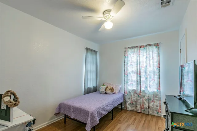 a bedroom with a bed and wooden floor