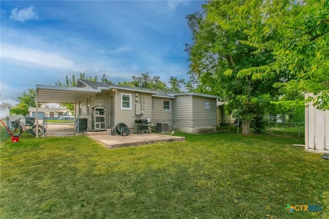 a view of a house with backyard and sitting area