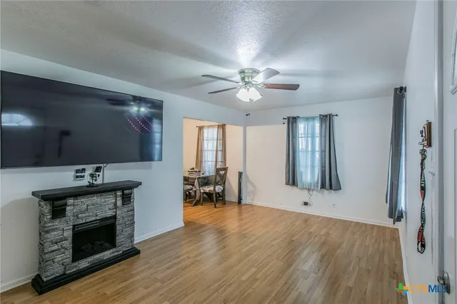 a view of an empty room with window and wooden floor