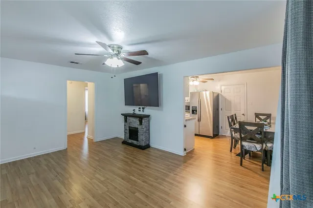 a view of a livingroom with furniture a ceiling fan and wooden floor