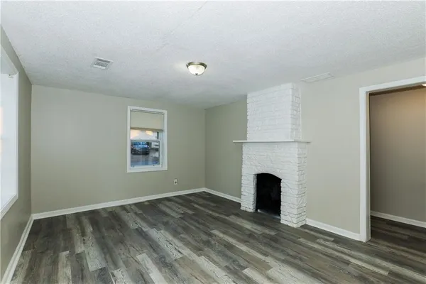 an empty room with fireplace and a window