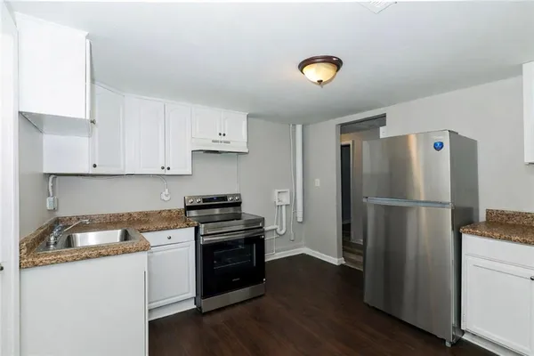 a kitchen with a refrigerator and a stove top oven