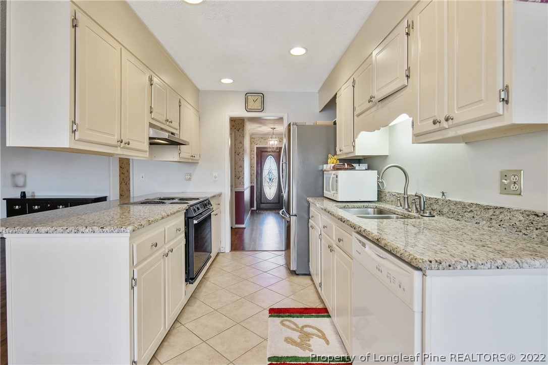 211 Duncan Road Spring Lake, NC 28390 - Photo 17 of 46 a kitchen with granite countertop a sink stove refrigerator and cabinets
