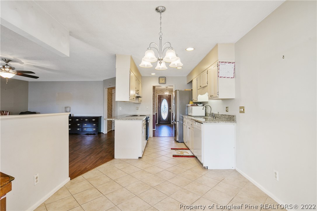 211 Duncan Road Spring Lake, NC 28390 - Photo 22 of 46 a kitchen with kitchen island a stove a refrigerator a sink dishwasher with a dining table and chairs