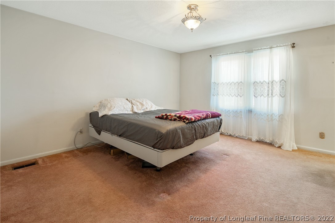 211 Duncan Road Spring Lake, NC 28390 - Photo 27 of 46 a spacious bedroom with a bed and a window