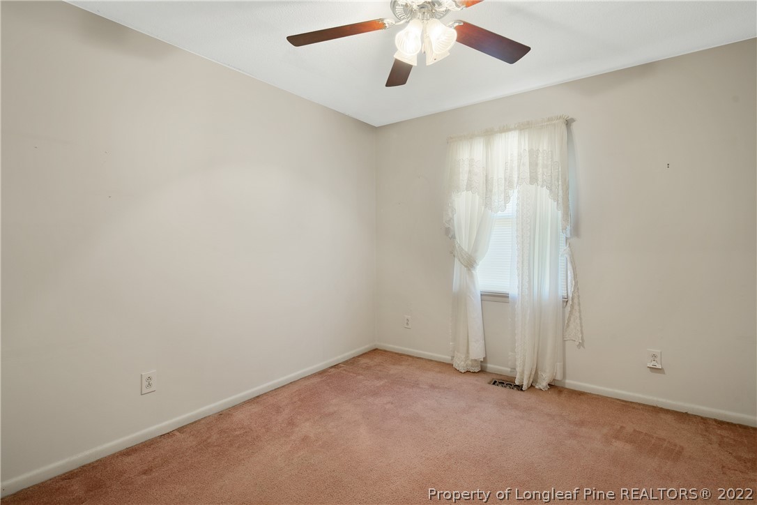 211 Duncan Road Spring Lake, NC 28390 - Photo 32 of 46 an empty room with a window and a ceiling fan