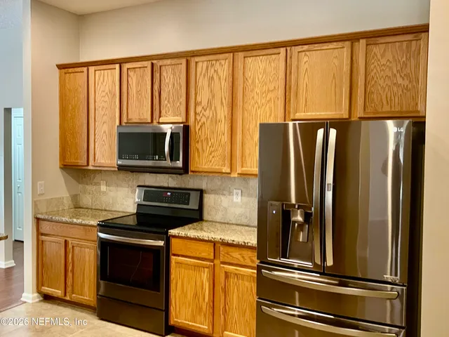 a kitchen with stainless steel appliances a refrigerator stove and microwave