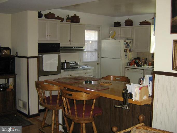 4003 Ferrara Drive Silver Spring, MD 20906 - Photo 21 of 29 a kitchen with stainless steel appliances granite countertop a sink refrigerator and microwave
