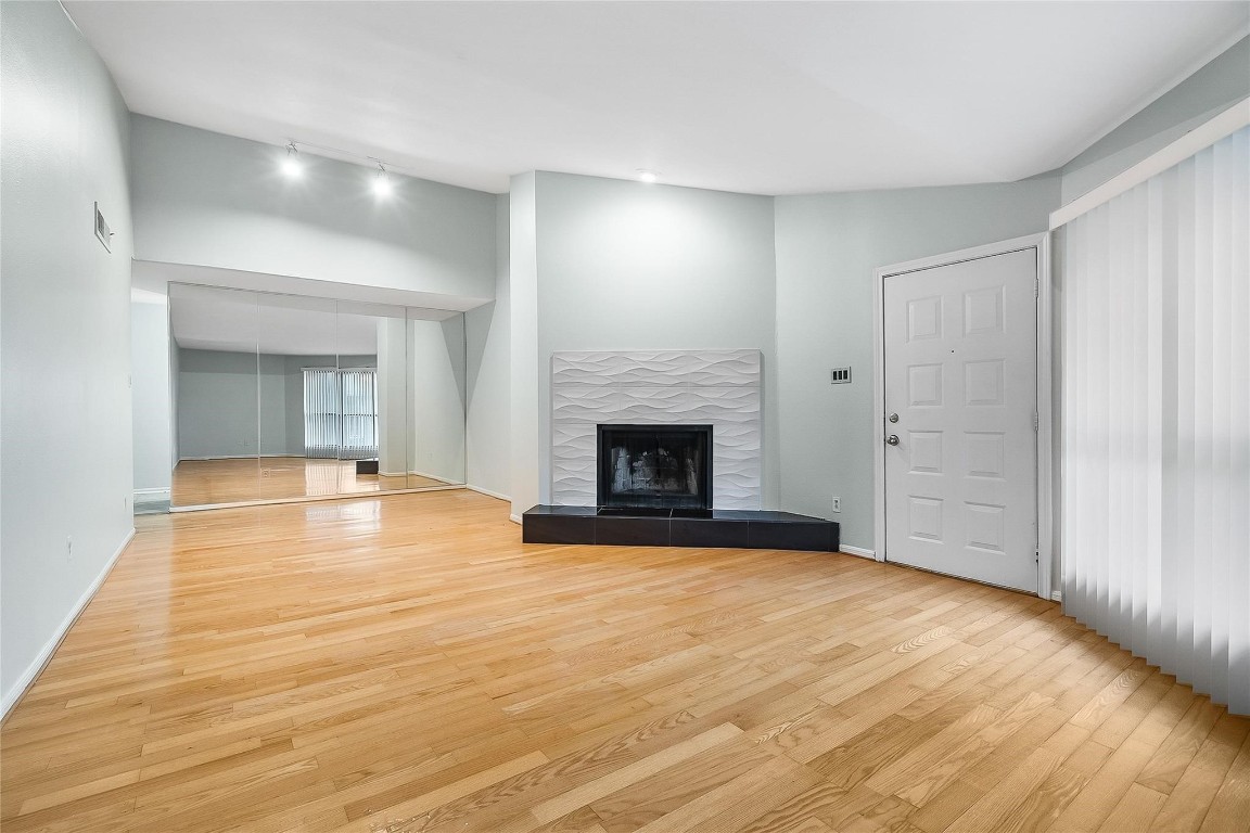 3100 Walnut Bend Lane, Unit 116 Houston, TX 77042 - Photo 2 of 15 a view of empty room with wooden floor and fireplace