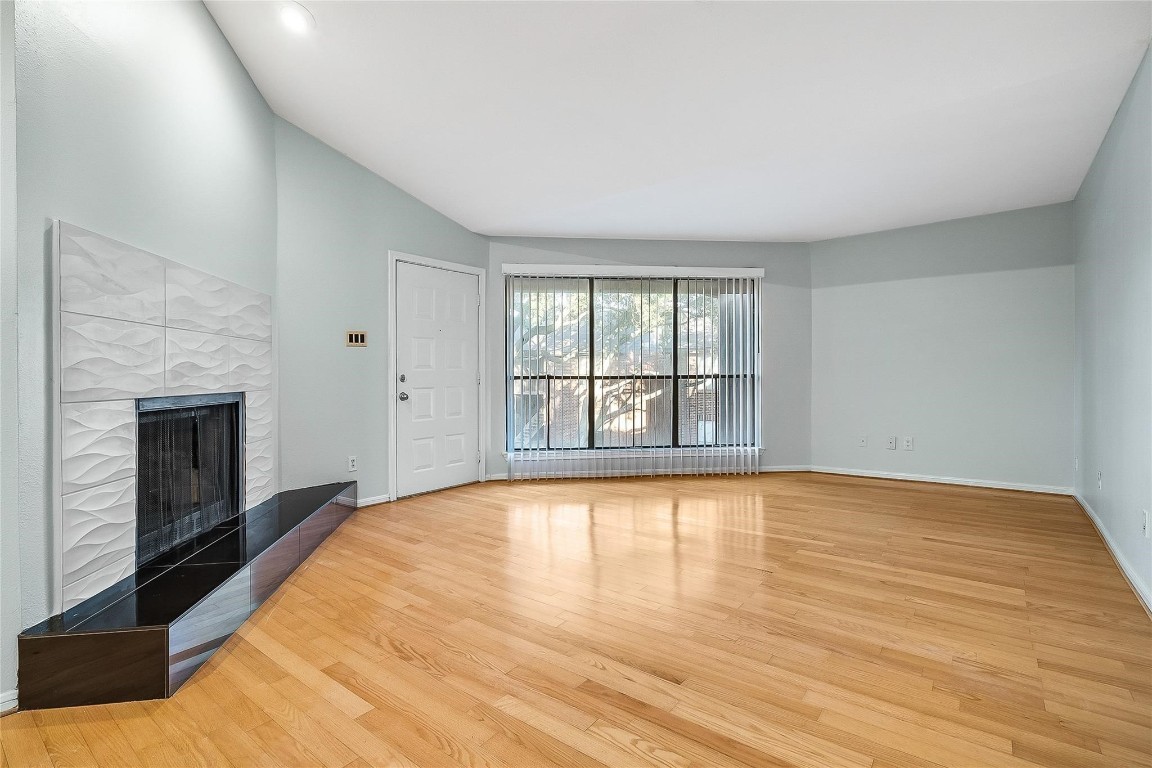 3100 Walnut Bend Lane, Unit 116 Houston, TX 77042 - Photo 3 of 15 a view of an empty room with wooden floor and a window