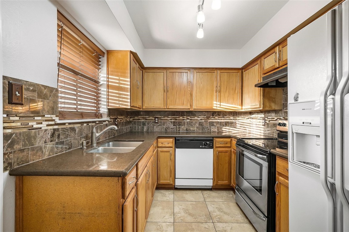 3100 Walnut Bend Lane, Unit 116 Houston, TX 77042 - Photo 7 of 15 a kitchen with stainless steel appliances granite countertop a sink stove and refrigerator