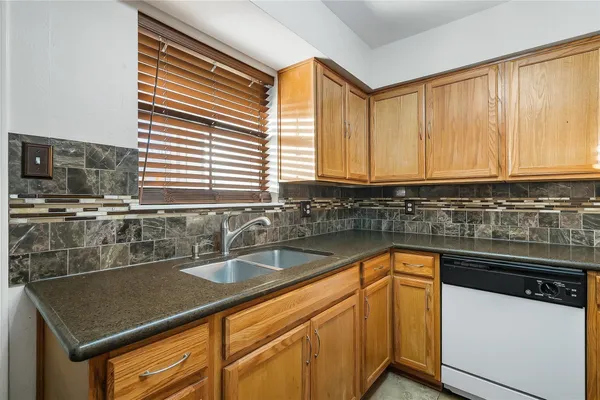 a kitchen with stainless steel appliances granite countertop a sink and a white cabinets