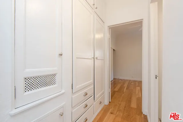 a view of a bedroom with wooden floor and cabinet