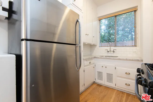 a kitchen with granite countertop a refrigerator and a sink
