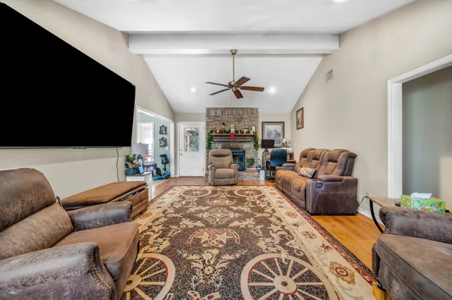 a living room with furniture a flat screen tv and a fireplace