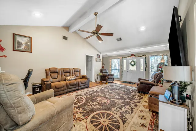 a living room with furniture ceiling fan and a rug