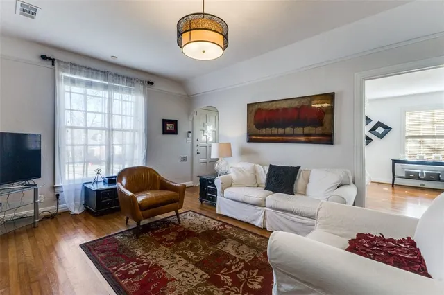 a living room with furniture a flat screen tv and a large window