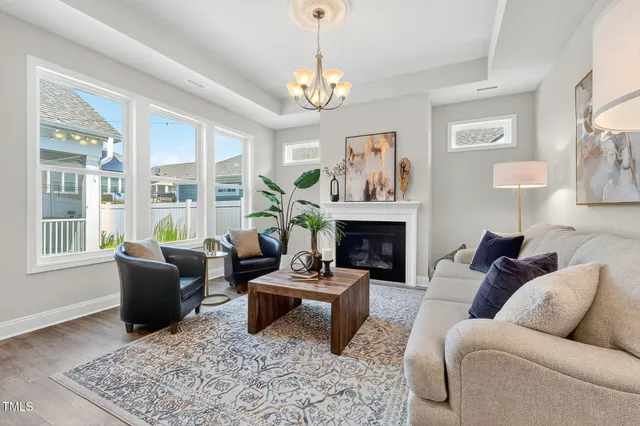 a living room with furniture a chandelier and a fireplace