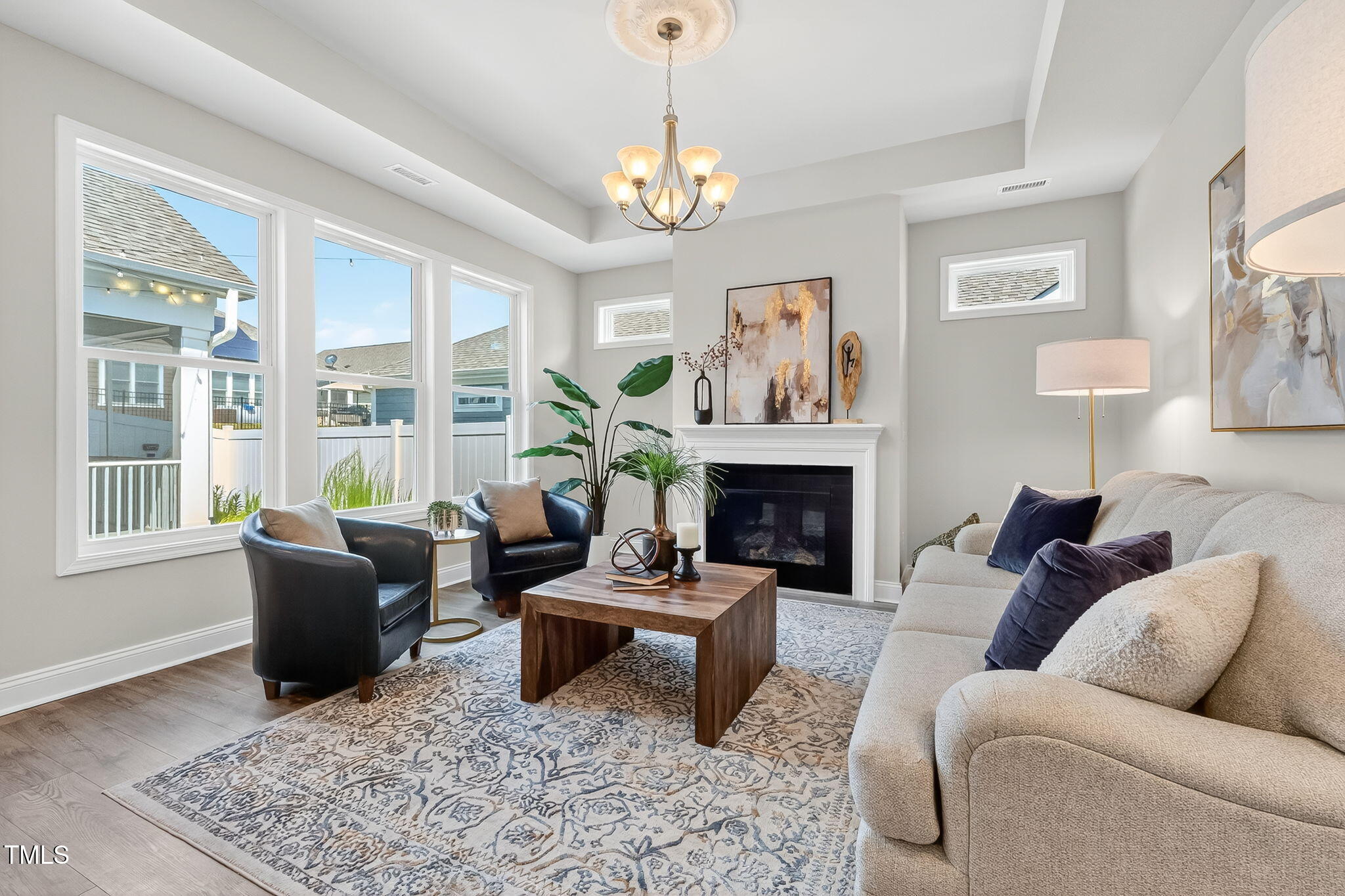a living room with furniture a chandelier and a fireplace