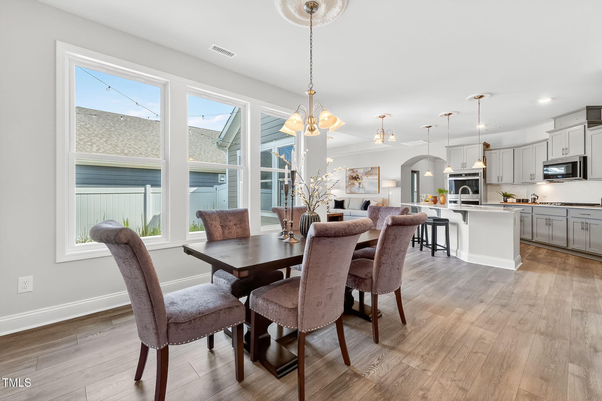 1217 Linkwood Way Fuquay-Varina, NC 27526 - Photo 18 of 44 a dining room kitchen with stainless steel appliances kitchen island granite countertop a stove a table and chairs