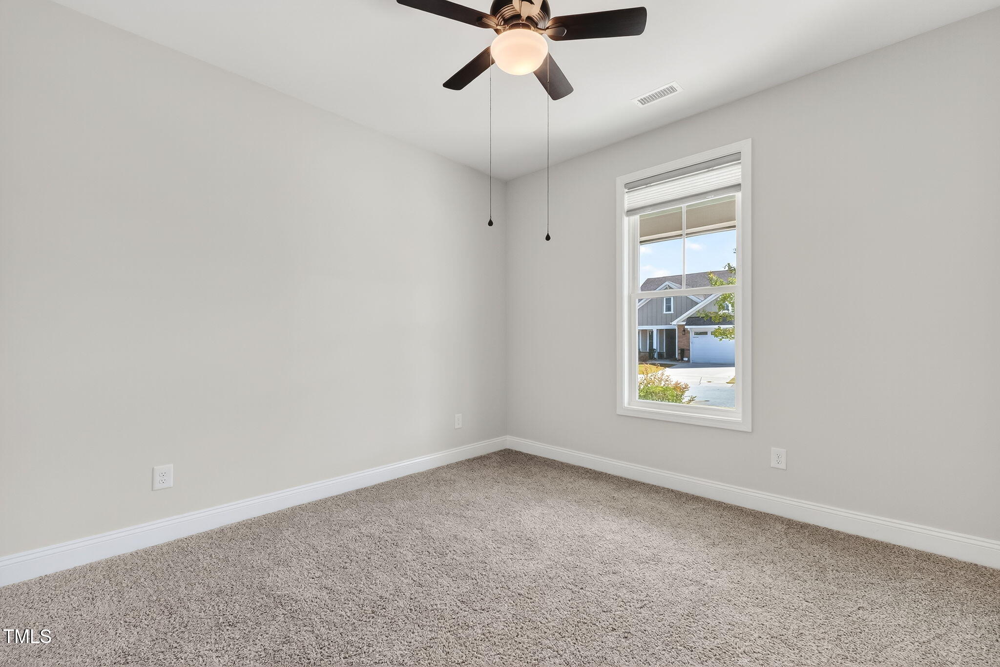 1217 Linkwood Way Fuquay-Varina, NC 27526 - Photo 29 of 44 an empty room with a window and a ceiling fan