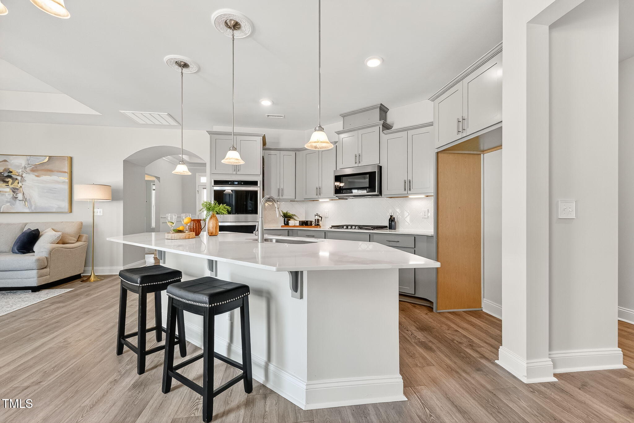 1217 Linkwood Way Fuquay-Varina, NC 27526 - Photo 9 of 44 a kitchen with stainless steel appliances kitchen island granite countertop a table chairs refrigerator and microwave