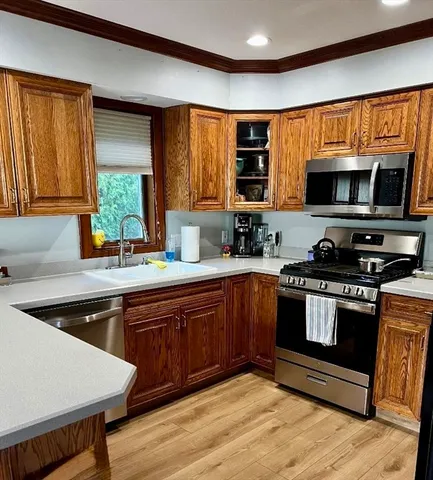 a kitchen with stainless steel appliances a stove a sink and a microwave