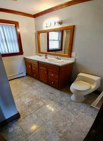 a bathroom with a toilet a sink and mirror