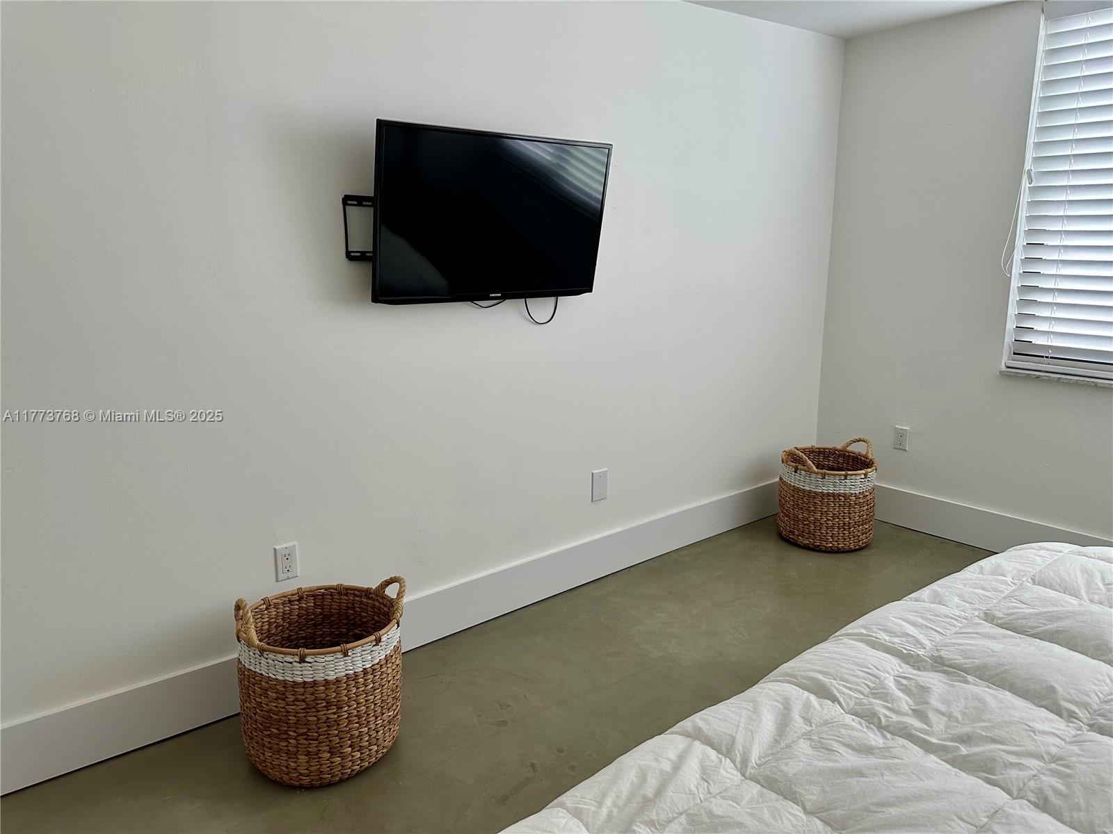 250 Galen Drive, Unit 25 Key Biscayne, FL 33149 - Photo 11 of 12 a room with a chair and a flat screen tv
