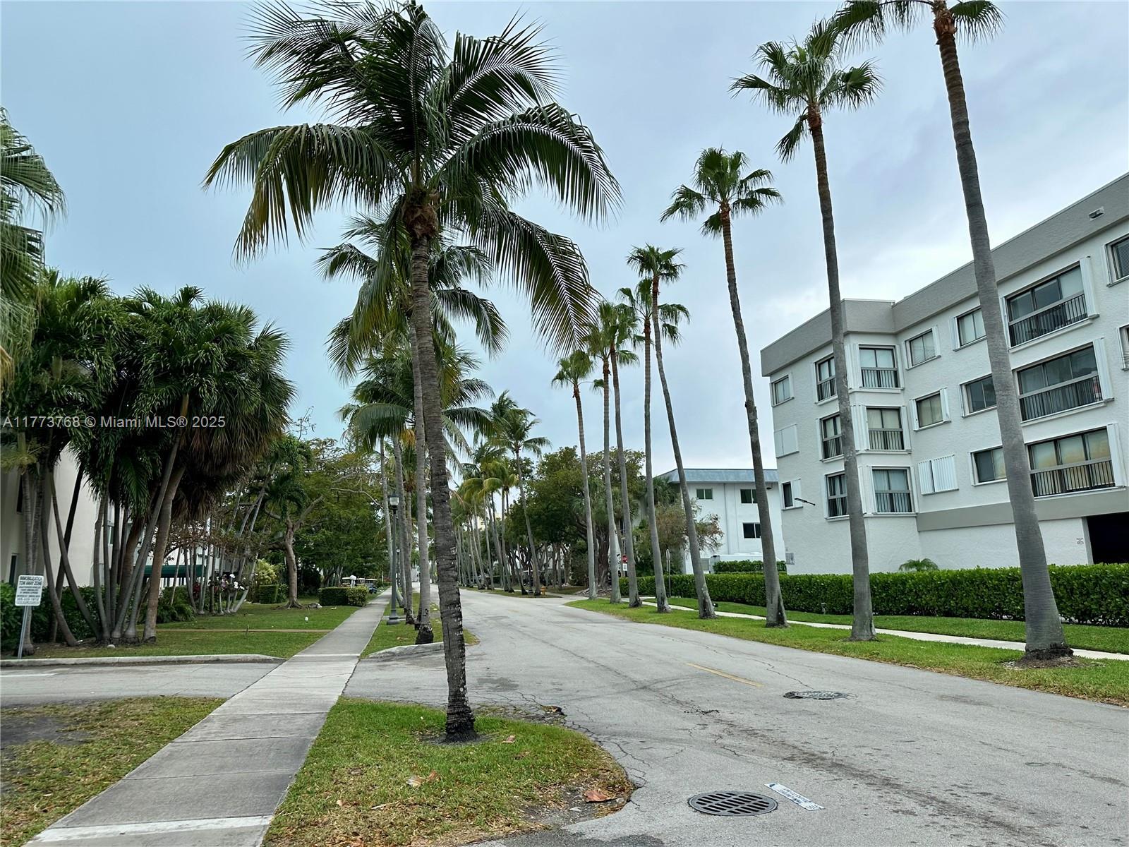 250 Galen Drive, Unit 25 Key Biscayne, FL 33149 - Photo 12 of 12 a front view of multi story residential apartment building with yard and green space