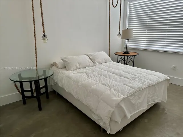 a bed sitting in a bedroom next to a lamp