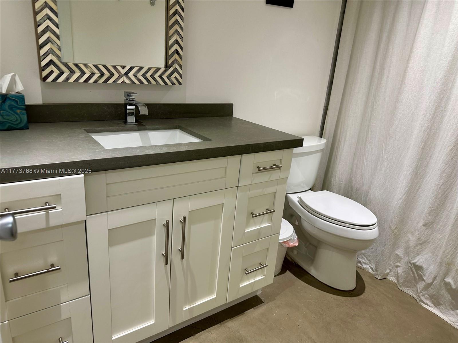 250 Galen Drive, Unit 25 Key Biscayne, FL 33149 - Photo 4 of 12 a bathroom with a granite countertop toilet and a sink