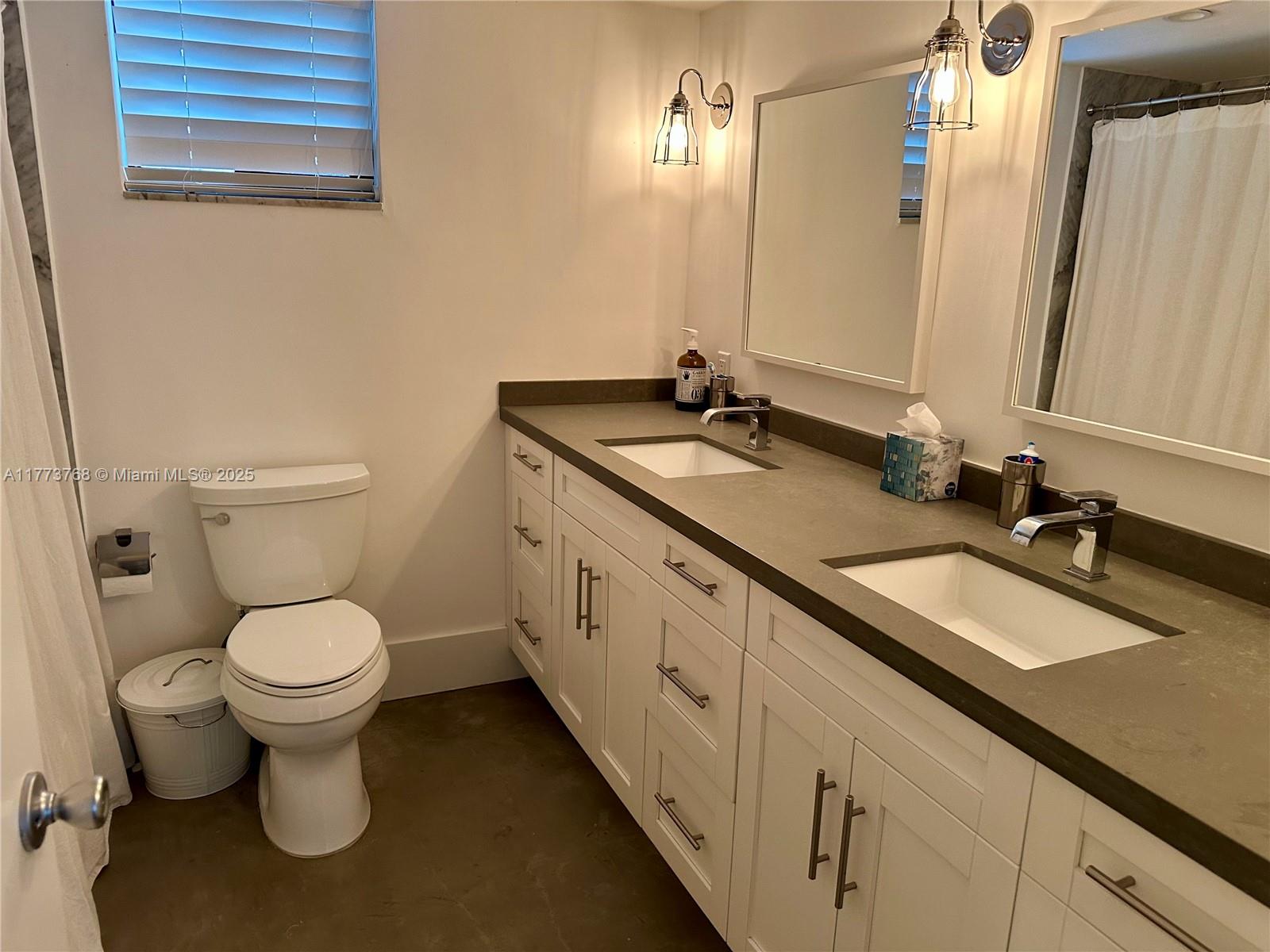 250 Galen Drive, Unit 25 Key Biscayne, FL 33149 - Photo 9 of 12 a bathroom with a double vanity sink toilet and a mirror