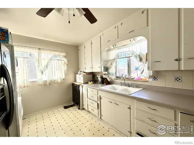a kitchen with a sink window and cabinets