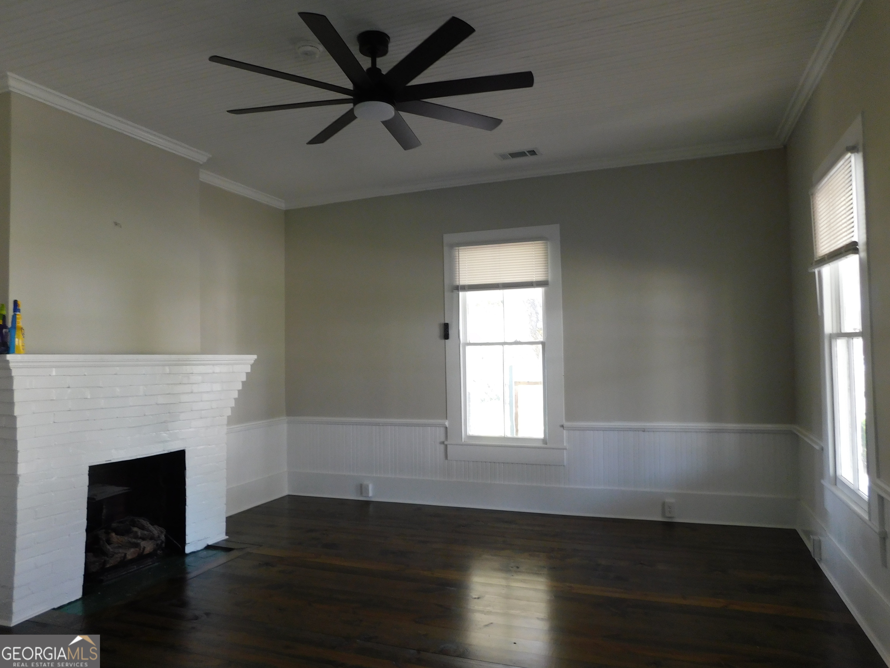 206 East Lane Street Brooklet, GA 30415 - Photo 12 of 33 an empty room with wooden floor fireplace and windows