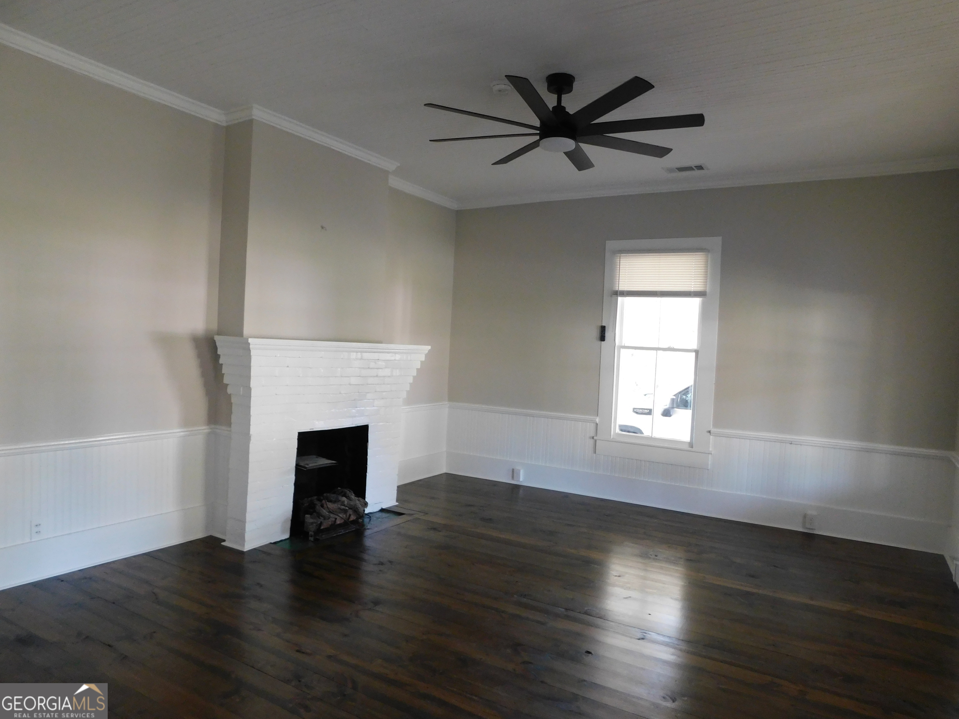 206 East Lane Street Brooklet, GA 30415 - Photo 13 of 33 an empty room with wooden floor a fireplace and windows