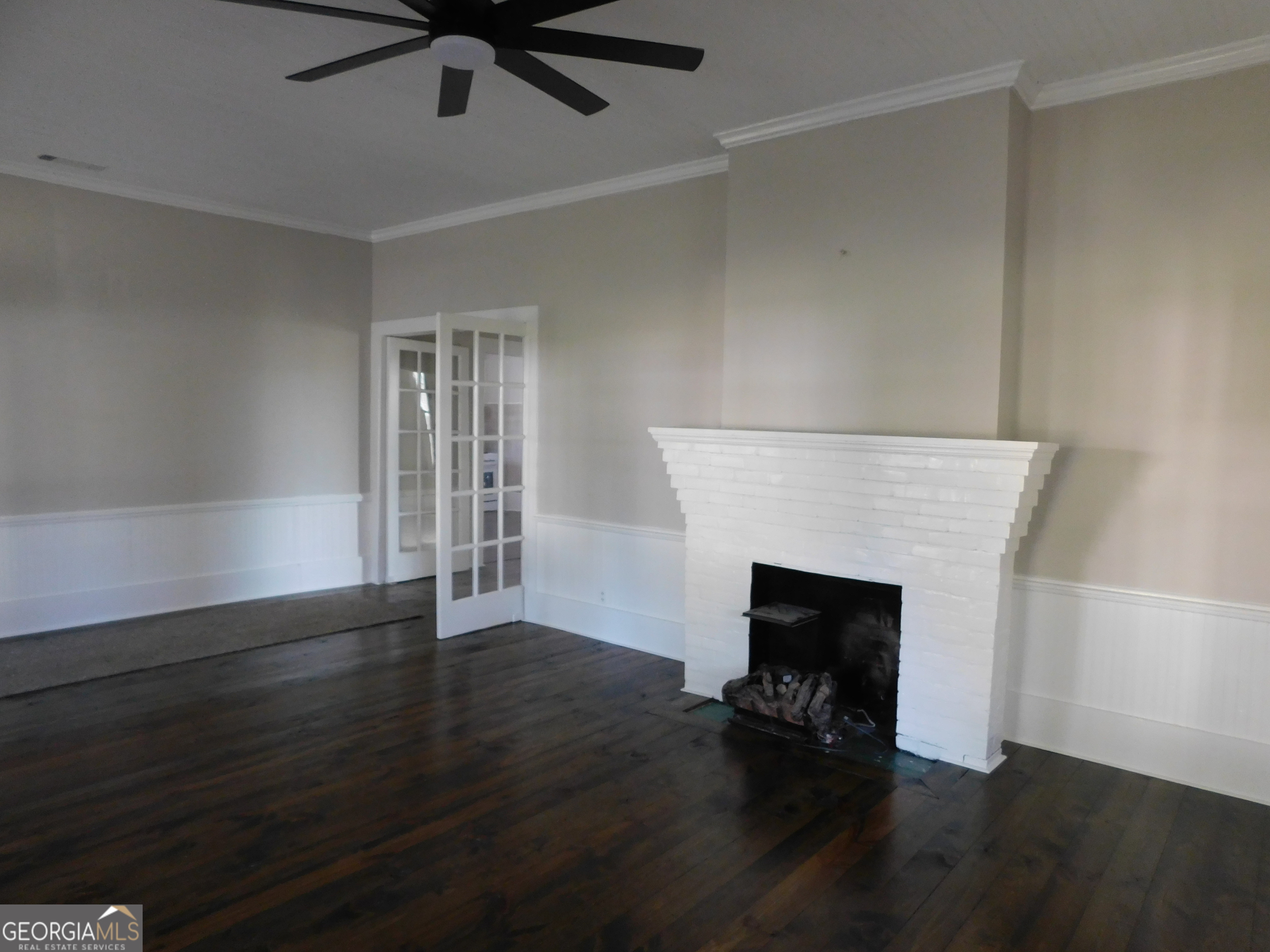 206 East Lane Street Brooklet, GA 30415 - Photo 26 of 33 an empty room with wooden floor a fireplace and windows