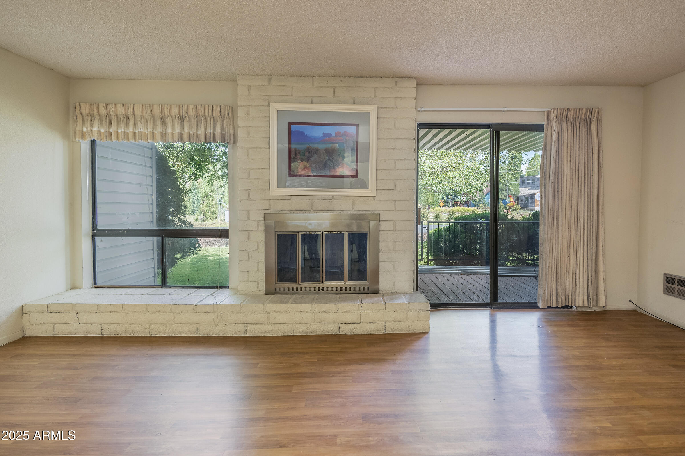 17980 Walapai Road, Unit 19A Munds Park, AZ 86017 - Photo 14 of 32 a view of wooden floor fireplace and windows in an empty room