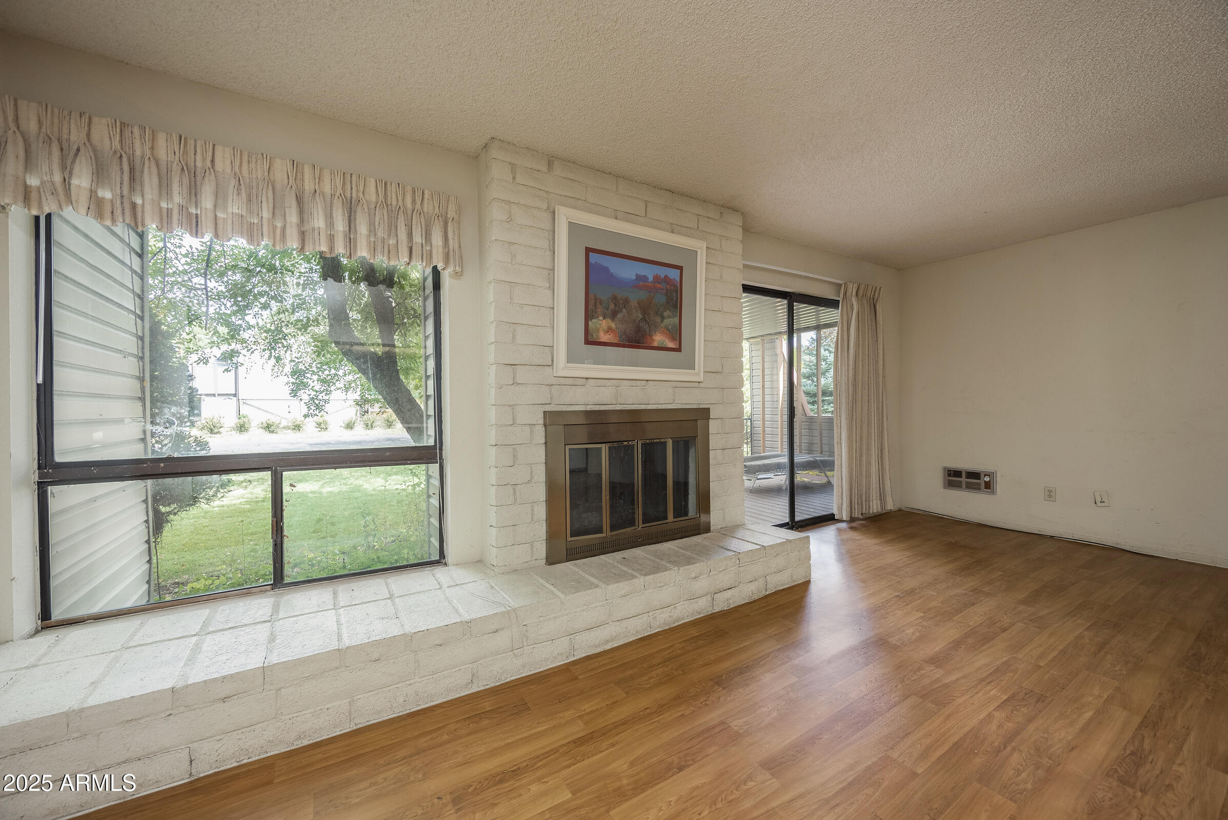 17980 Walapai Road, Unit 19A Munds Park, AZ 86017 - Photo 15 of 32 an empty room with windows and fireplace