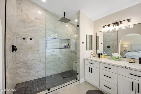 a bathroom with a double vanity sink mirror and shower