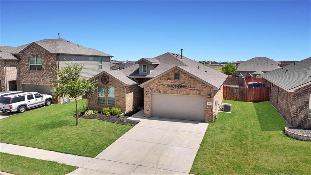 1402 Pleasanton Road Cleburne, TX 76033 - Photo 31 of 36 Brick exterior with an attached garage, paved driveway, and a front yard with mature landscaping