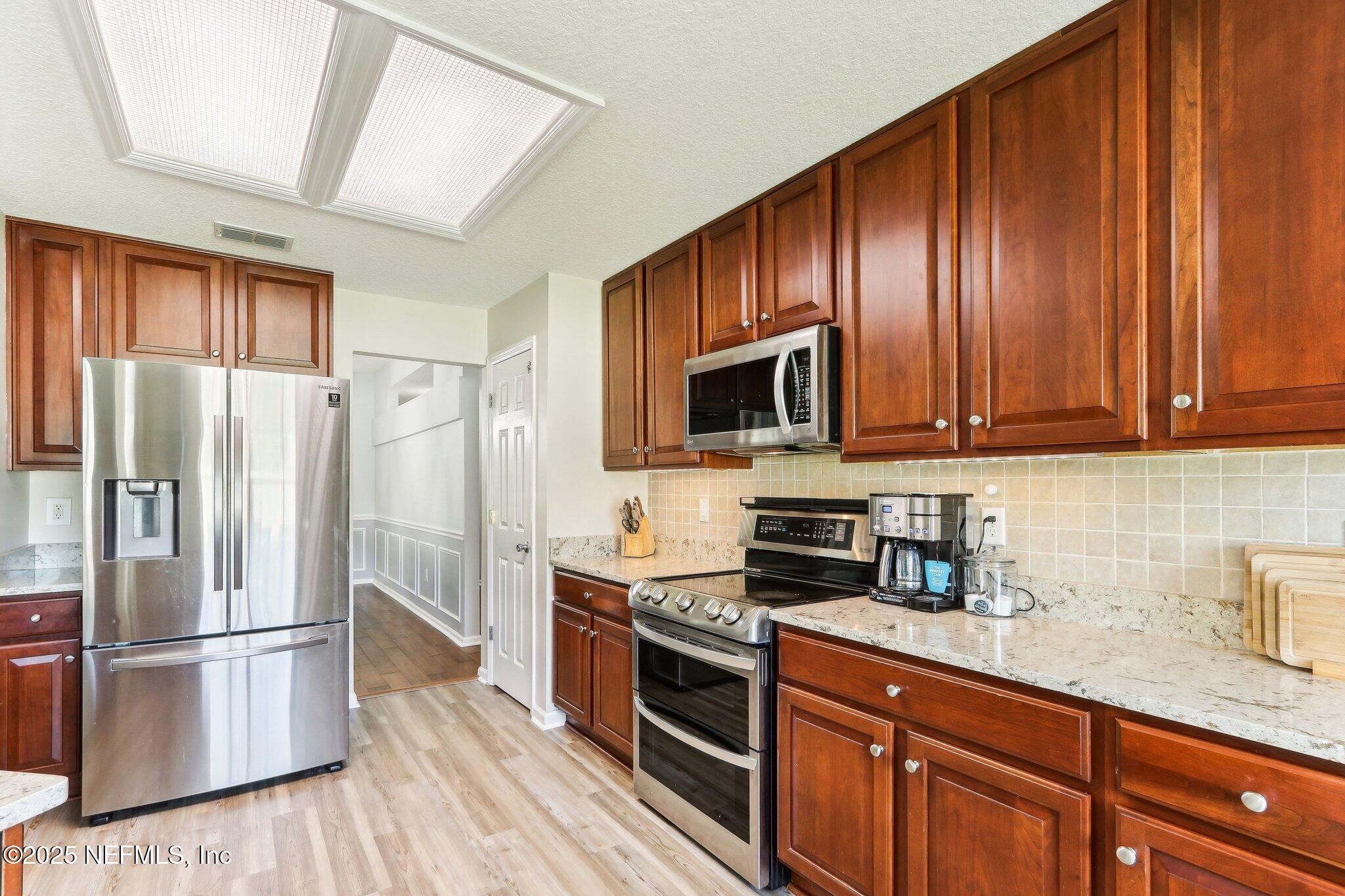 2124 Pond Spring Way Fleming Island, FL 32003 - Photo 17 of 56 a kitchen with stainless steel appliances granite countertop a refrigerator microwave and sink