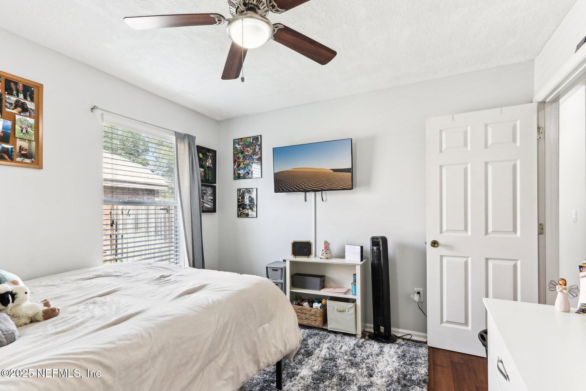 2124 Pond Spring Way Fleming Island, FL 32003 - Photo 23 of 56 a bedroom with a bed and a flat screen tv