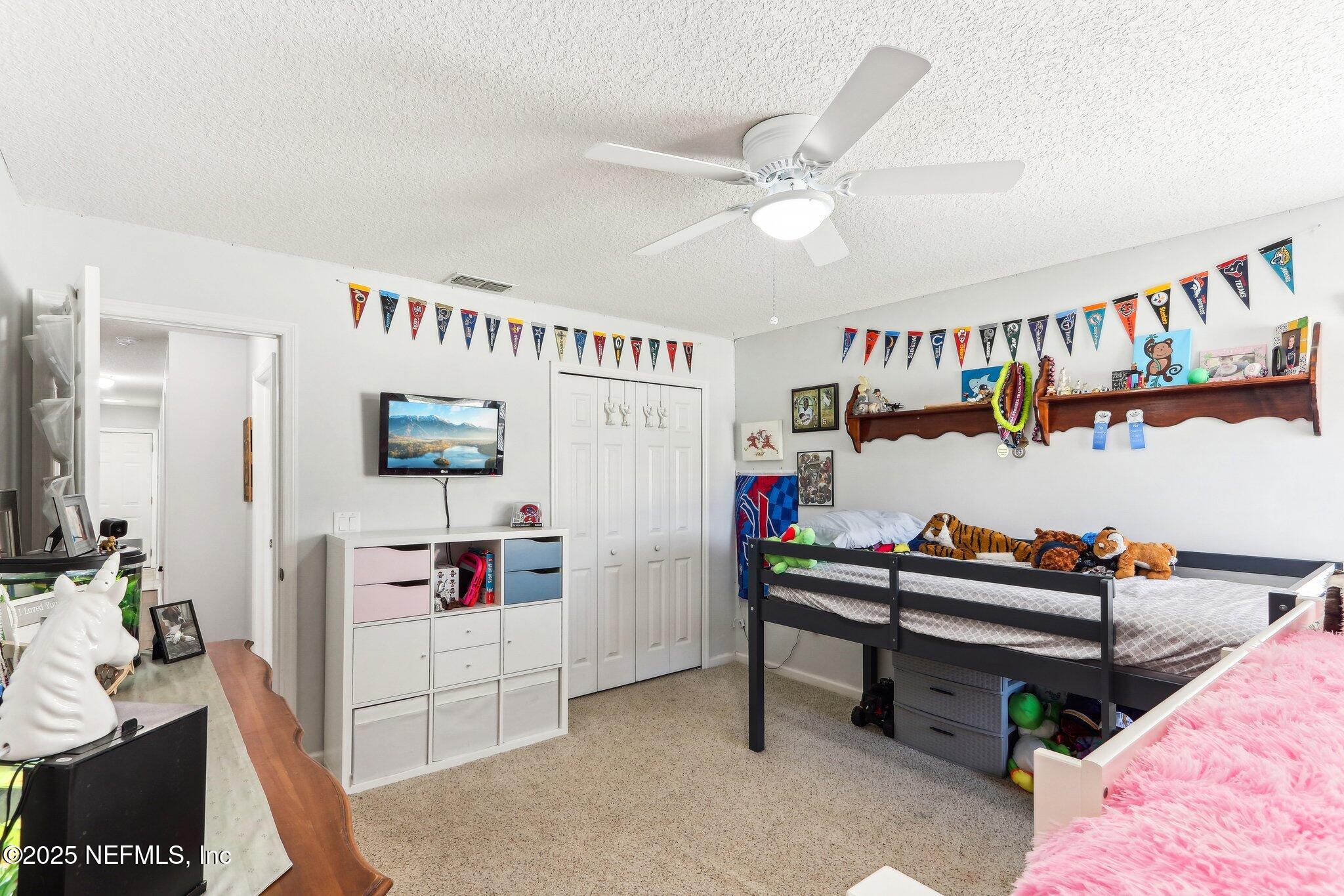 2124 Pond Spring Way Fleming Island, FL 32003 - Photo 26 of 56 a living room with furniture and a book shelf