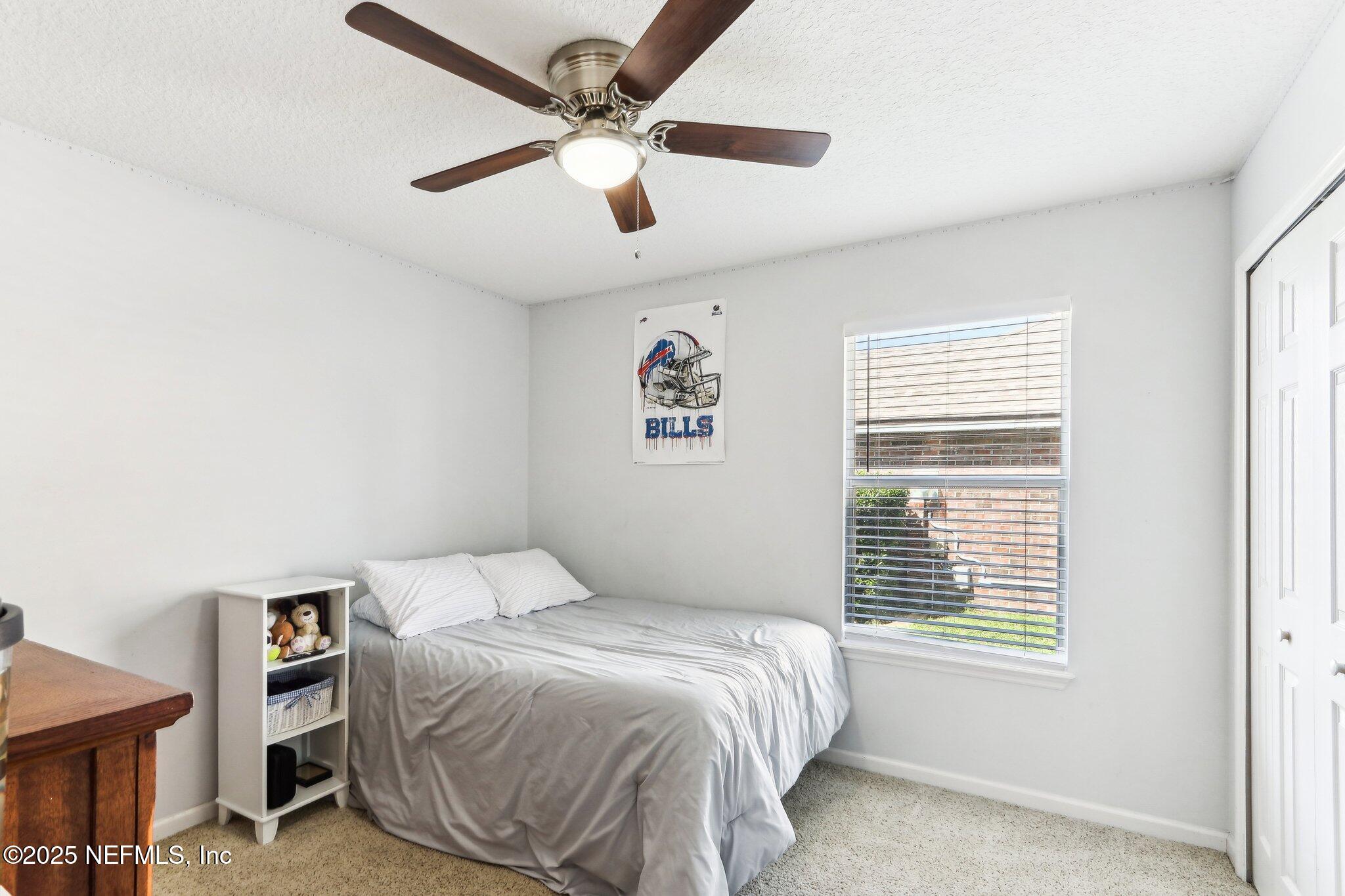 2124 Pond Spring Way Fleming Island, FL 32003 - Photo 27 of 56 a bedroom with a large bed and a window