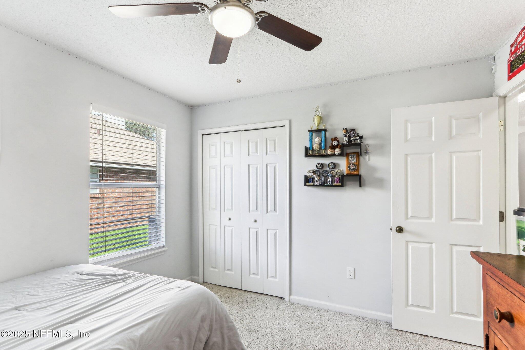 2124 Pond Spring Way Fleming Island, FL 32003 - Photo 28 of 56 a bedroom with a bed and a chandelier