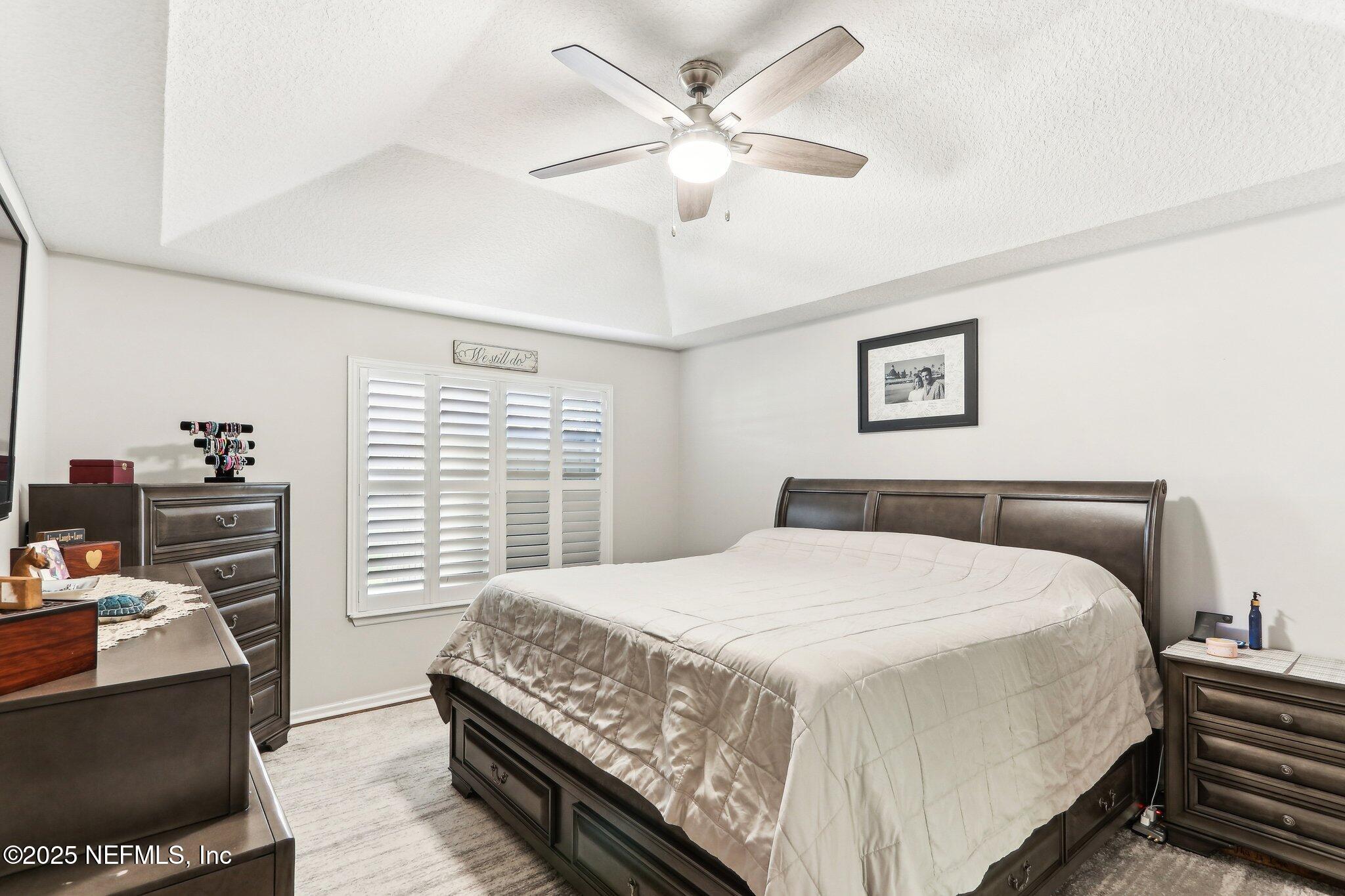 2124 Pond Spring Way Fleming Island, FL 32003 - Photo 30 of 56 a bedroom with a bed a window and a chandelier