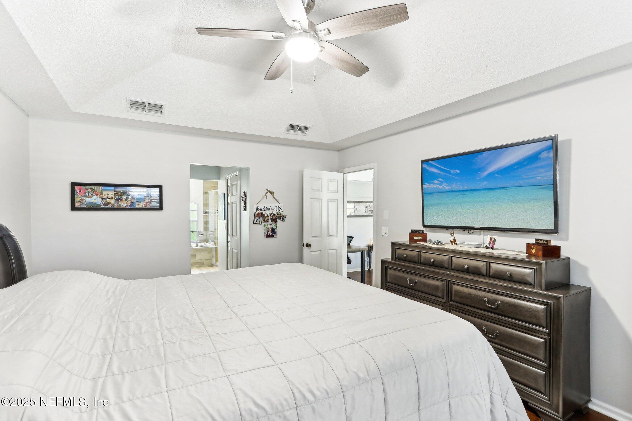 2124 Pond Spring Way Fleming Island, FL 32003 - Photo 31 of 56 a bedroom with a bed and a flat screen tv