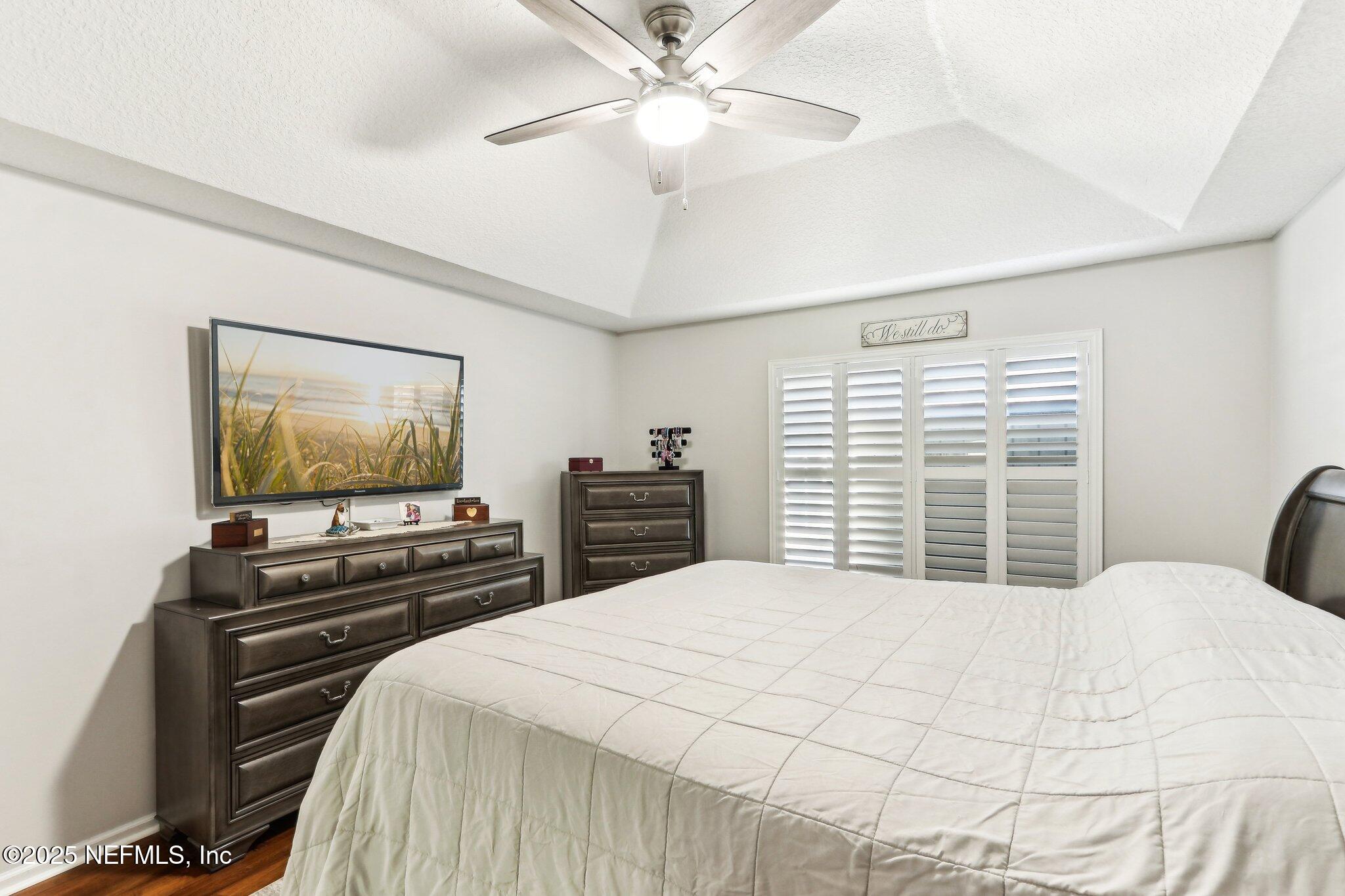 2124 Pond Spring Way Fleming Island, FL 32003 - Photo 32 of 56 a bedroom with a bed and a flat screen tv