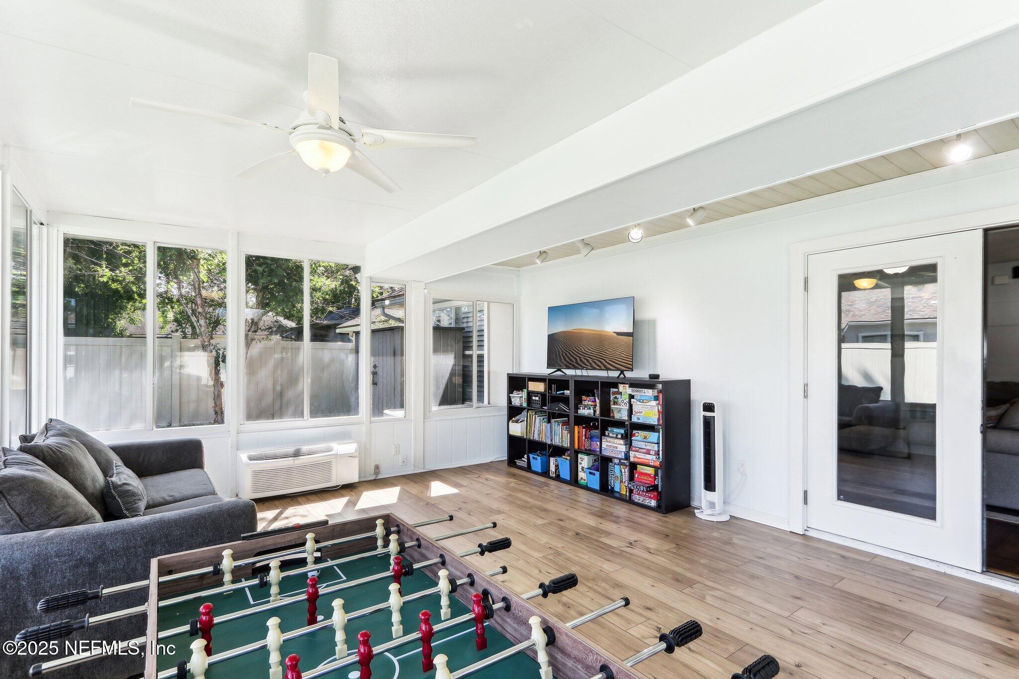 2124 Pond Spring Way Fleming Island, FL 32003 - Photo 38 of 56 a living room with furniture a flat screen tv and floor to ceiling window